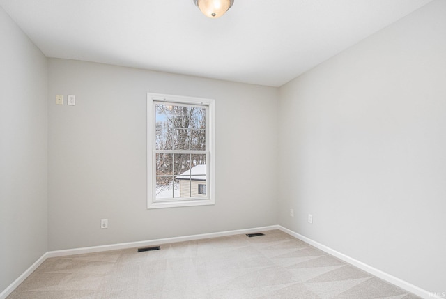 spare room featuring light carpet