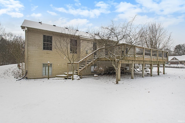 snow covered property featuring a wooden deck