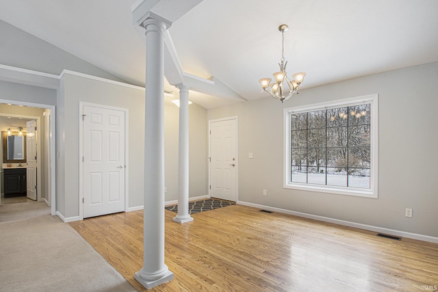 entryway featuring lofted ceiling, an inviting chandelier, sink, light wood-type flooring, and decorative columns