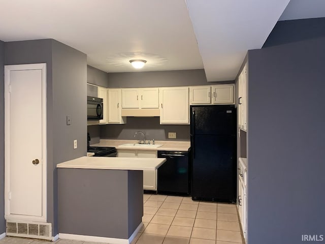 kitchen featuring white cabinets, sink, light tile patterned flooring, and black appliances