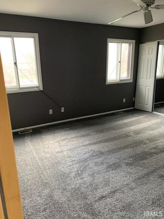 empty room featuring carpet flooring and ceiling fan