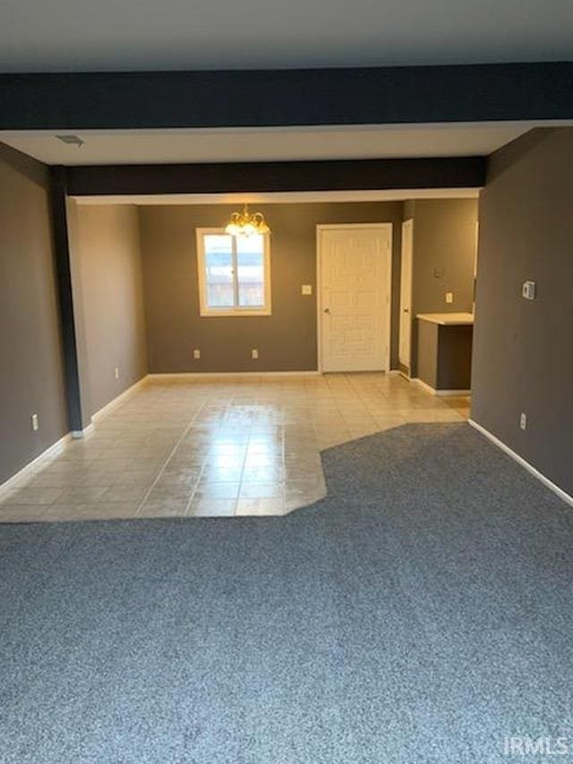 spare room featuring light tile patterned floors and a chandelier