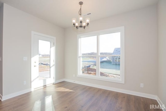 unfurnished room featuring hardwood / wood-style floors and an inviting chandelier