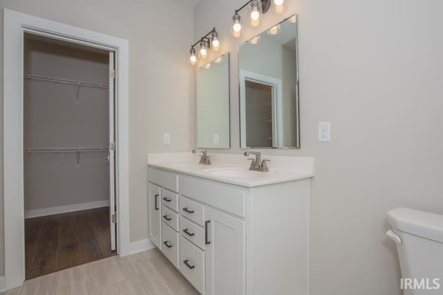 bathroom with vanity, toilet, and wood-type flooring