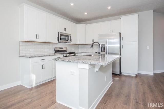 kitchen with a center island with sink, sink, white cabinetry, and stainless steel appliances