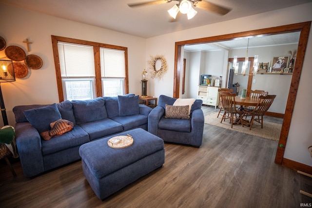 living room with ceiling fan with notable chandelier and dark hardwood / wood-style flooring