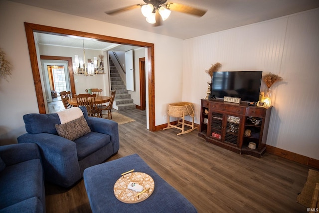 living room with dark hardwood / wood-style flooring and ceiling fan with notable chandelier