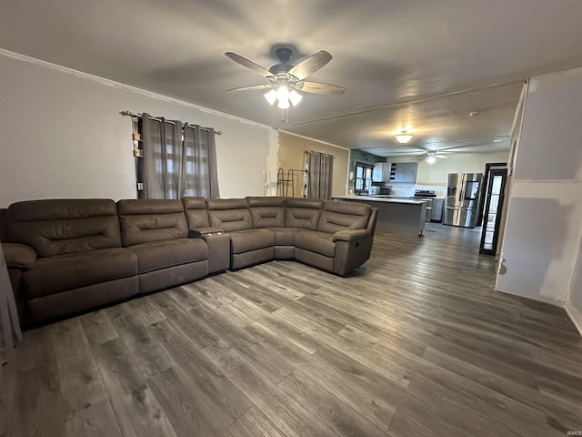 living room with hardwood / wood-style flooring, ceiling fan, and crown molding