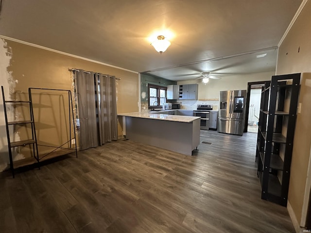 kitchen with sink, dark hardwood / wood-style floors, appliances with stainless steel finishes, kitchen peninsula, and a breakfast bar area