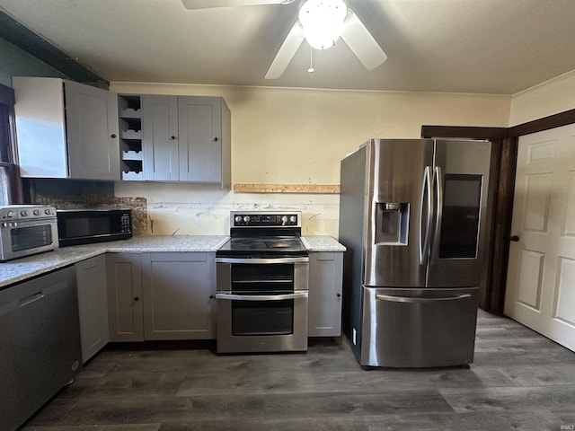 kitchen with ceiling fan, light stone counters, dark hardwood / wood-style flooring, gray cabinets, and appliances with stainless steel finishes