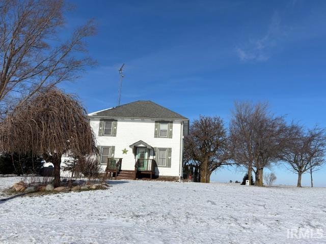 view of snow covered back of property