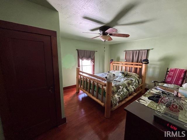 bedroom featuring ceiling fan, dark hardwood / wood-style flooring, and a textured ceiling