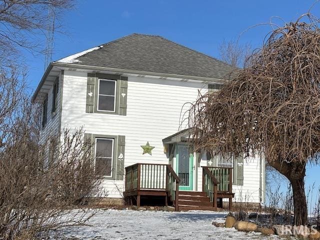 view of snow covered back of property