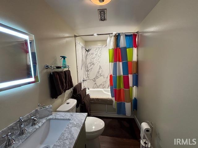 full bathroom featuring toilet, vanity, and shower / tub combo with curtain