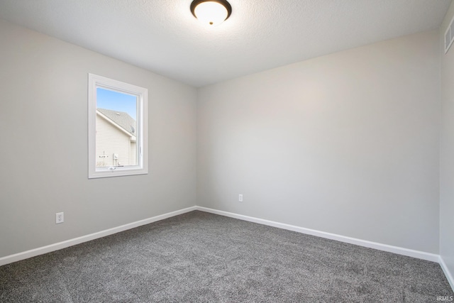 carpeted empty room featuring a textured ceiling