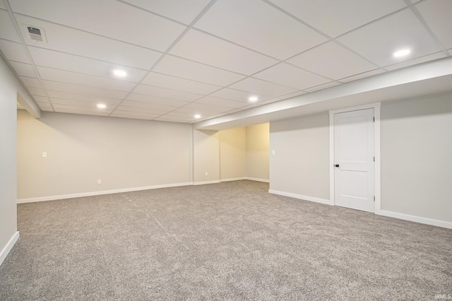 basement with carpet and a paneled ceiling