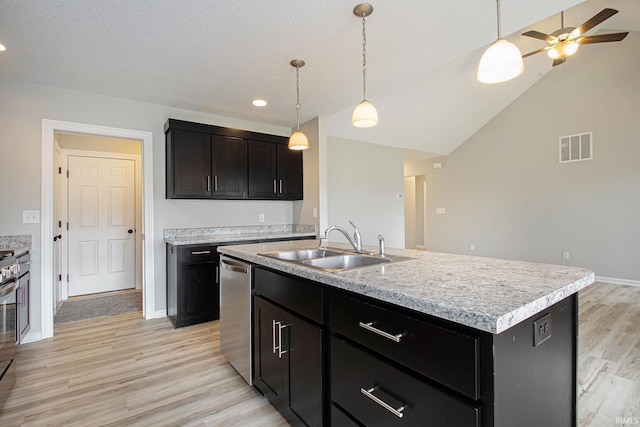 kitchen with ceiling fan, sink, light hardwood / wood-style flooring, pendant lighting, and a kitchen island with sink