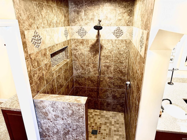 bathroom featuring tiled shower and vanity