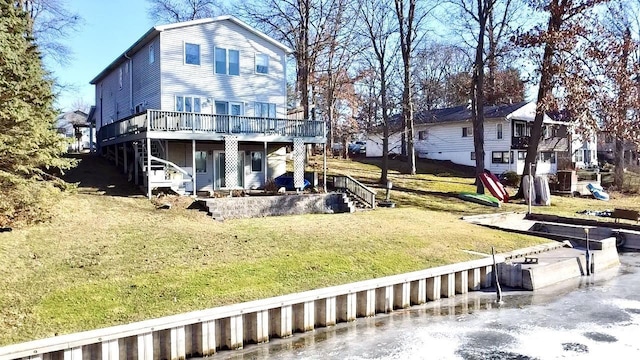 back of property with a yard and a wooden deck