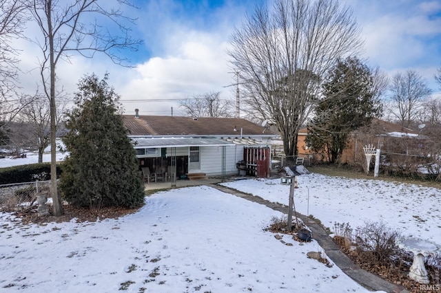 view of snow covered back of property