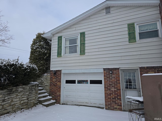 view of snow covered exterior with a garage