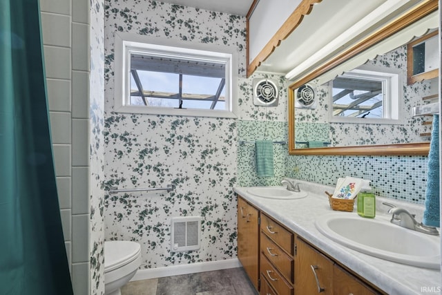 bathroom featuring toilet, vanity, and a shower with curtain