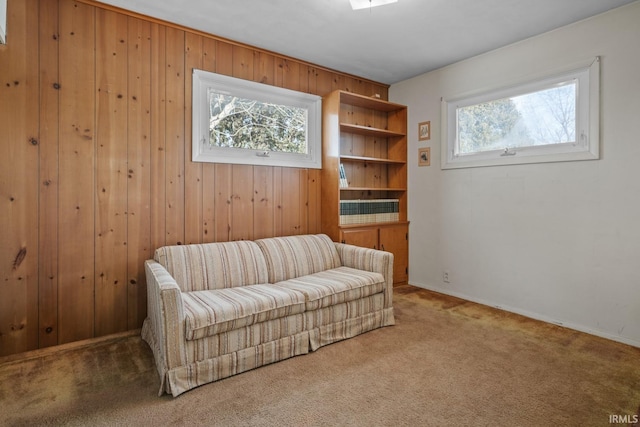 sitting room with carpet and wooden walls