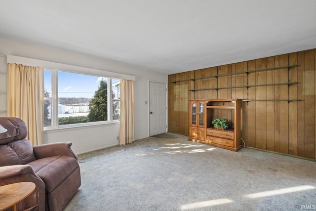 unfurnished living room featuring wood walls and carpet floors