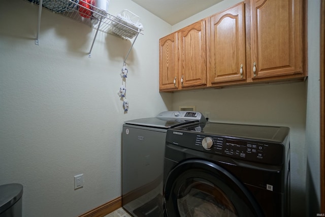 laundry room featuring washing machine and dryer and cabinets