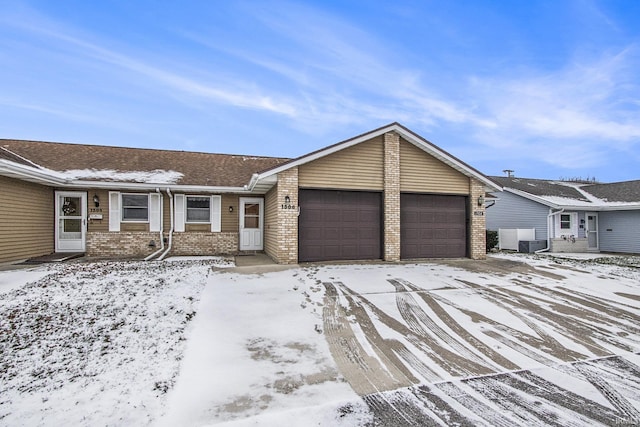 single story home featuring cooling unit and a garage