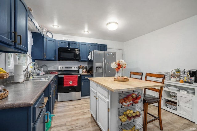 kitchen featuring sink, light wood-type flooring, blue cabinetry, a kitchen bar, and stainless steel appliances