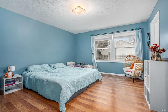 bedroom featuring a textured ceiling and hardwood / wood-style flooring