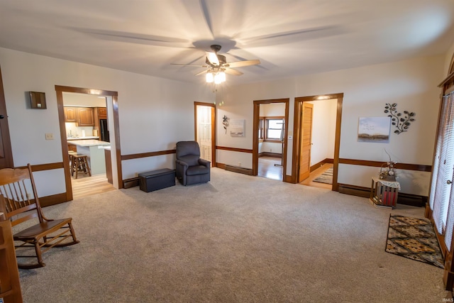 sitting room featuring light colored carpet and ceiling fan