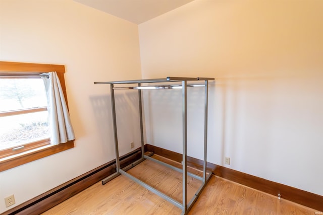 bedroom with baseboard heating and light hardwood / wood-style flooring