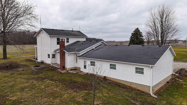 rear view of house featuring a yard