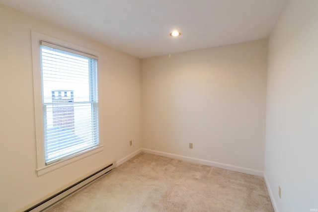 unfurnished room with a wealth of natural light, light colored carpet, and a baseboard heating unit