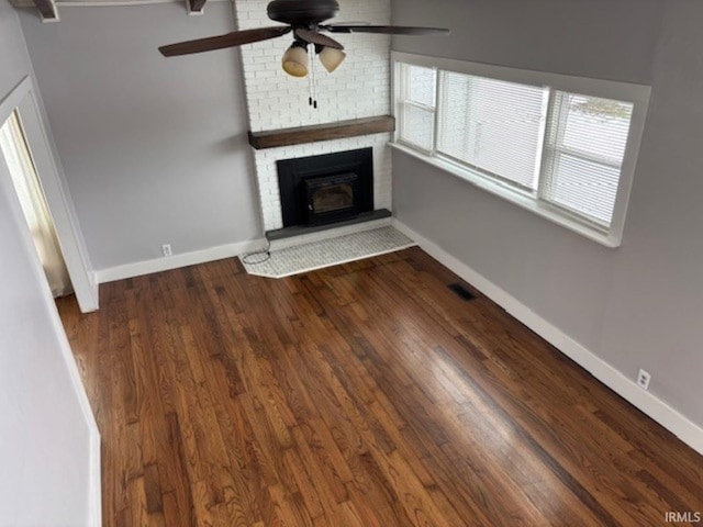 unfurnished living room featuring ceiling fan and dark wood-type flooring