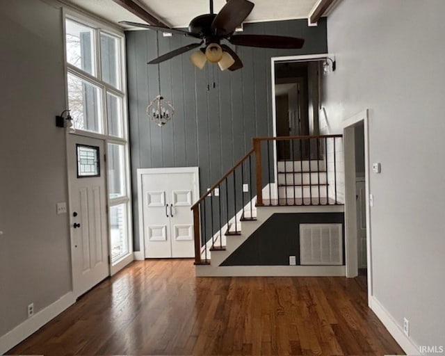 entryway featuring beam ceiling, ceiling fan, wood walls, and dark hardwood / wood-style floors