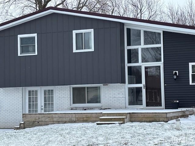 view of snow covered back of property