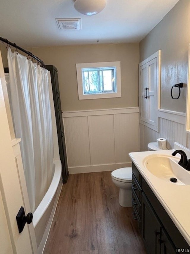 full bathroom with shower / bath combo, vanity, hardwood / wood-style flooring, and toilet