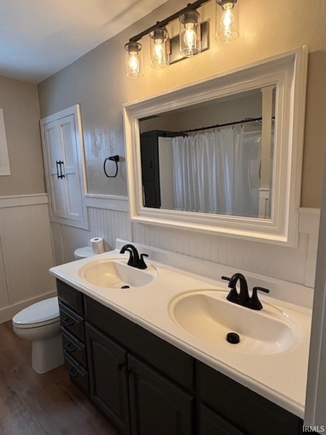 bathroom with hardwood / wood-style floors, vanity, and toilet