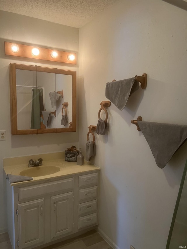 bathroom with a textured ceiling and vanity