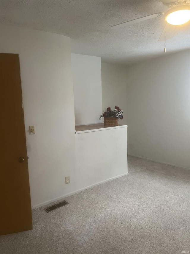 carpeted spare room featuring a textured ceiling