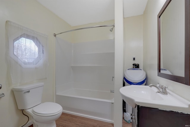 bathroom with bathtub / shower combination, hardwood / wood-style floors, and toilet