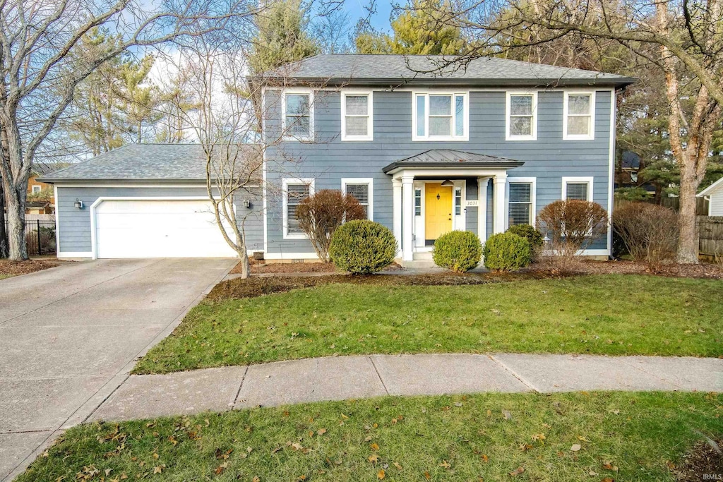 colonial-style house with a garage and a front lawn