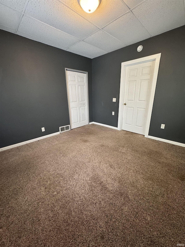 interior space featuring a drop ceiling and carpet