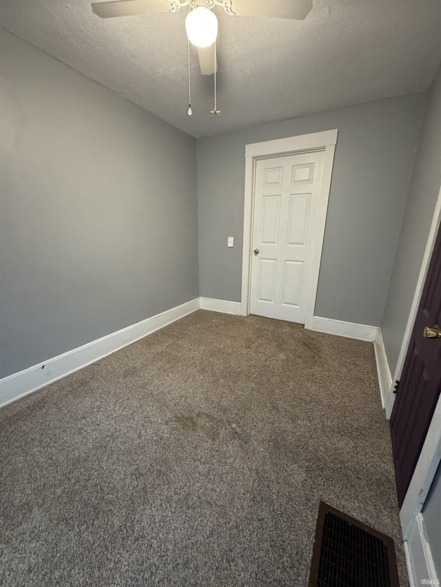 carpeted empty room featuring a textured ceiling and ceiling fan