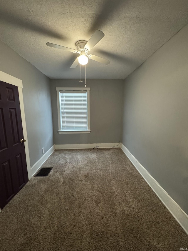 carpeted empty room with ceiling fan and a textured ceiling