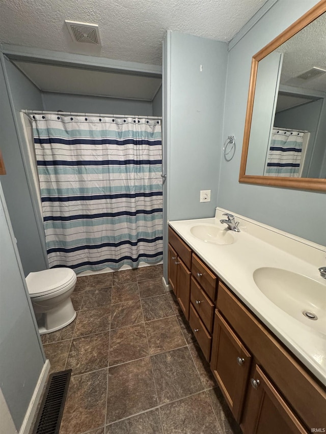 bathroom with a textured ceiling, vanity, toilet, and curtained shower