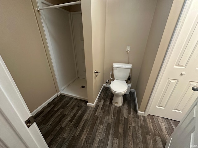 bathroom with hardwood / wood-style flooring, toilet, and a shower